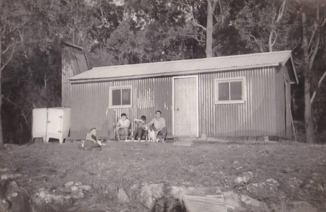 Outdoors Men: Bob Skelton holding a foxhound at his hut on the Karuah River, with his twin Dave and two mates. 