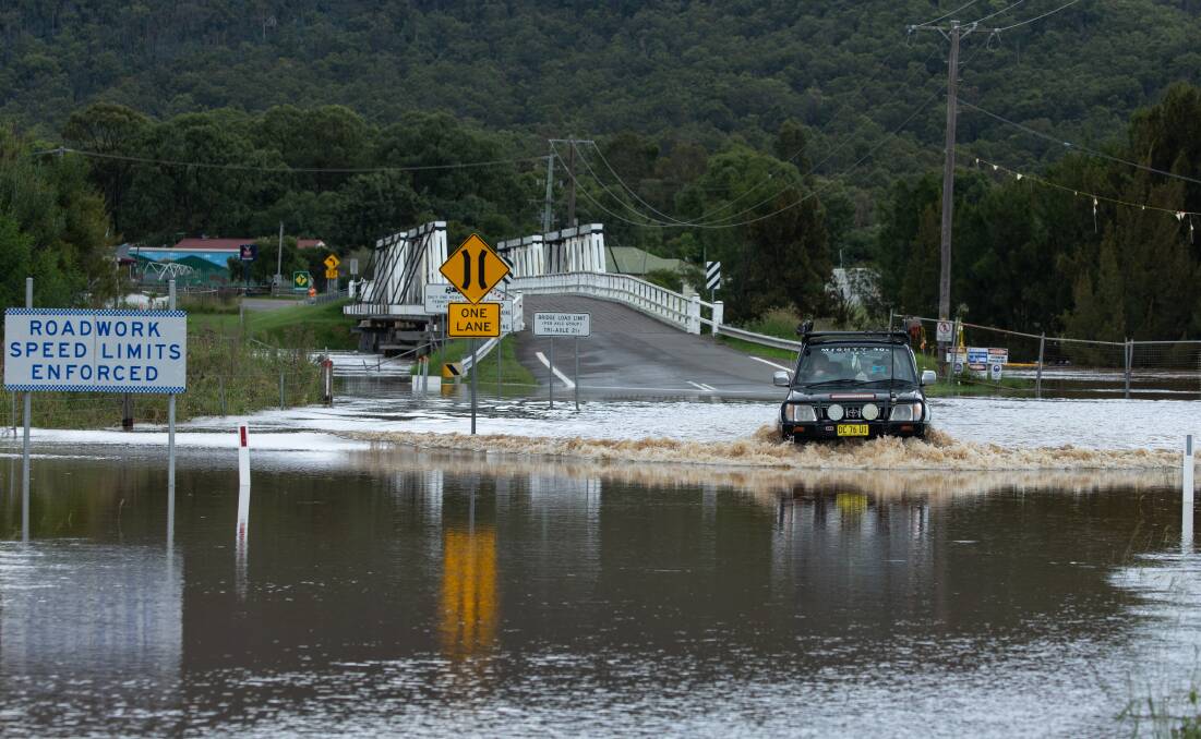 Full Flood: A four-wheel drive in floodwater on Putty Road at Bulga in early March. A rainfall record was set at Bulga in March. Picture: Marina Neil 