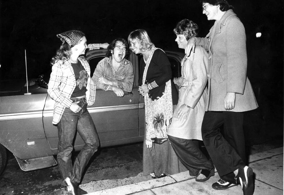 Bob Hudson, who performed The Newcastle Song, chats up some women, in Hunter Street in April 1975. Picture: Allan Jolly.   

