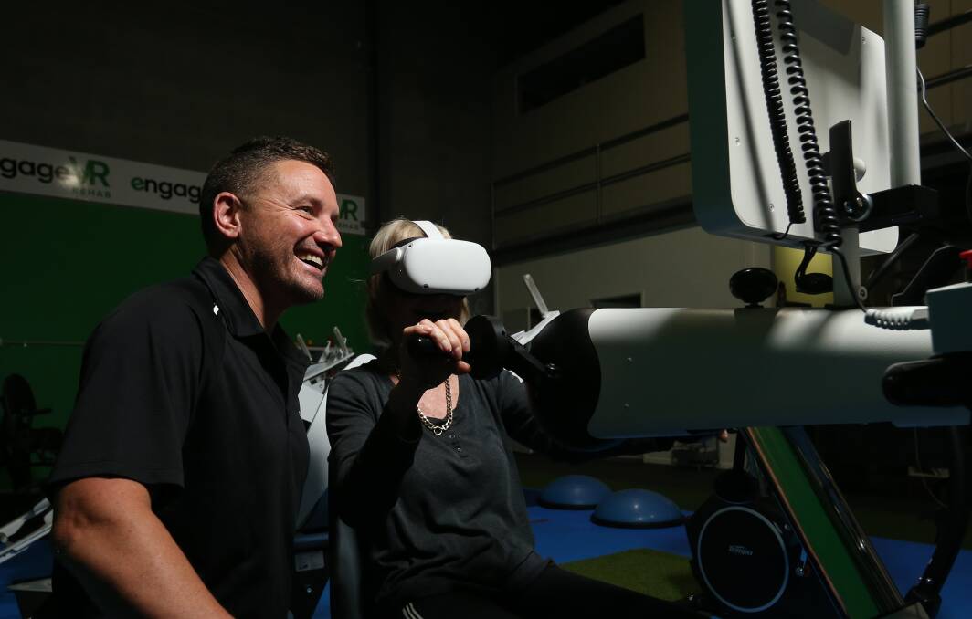  Virtual World: Craig Hewat with client Sandy Irons using a motorised movement therapy device, paired with virtual reality. Picture: Simone De Peak 