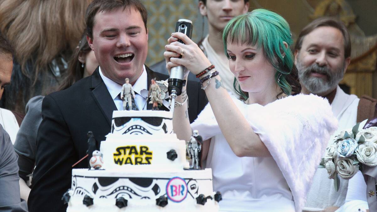 Singleton's Caroline Ritter cuts the cake at her Star Wars wedding to Andrew Porters outside the Chinese Theatre in Hollywood.
