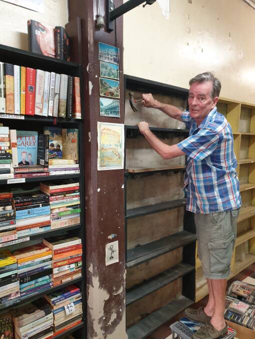 Shelved: Leigh Rice removing bookshelves from his famous store, which is moving to Tighes Hill. He has about 200 metres of shelving that he's giving away. 