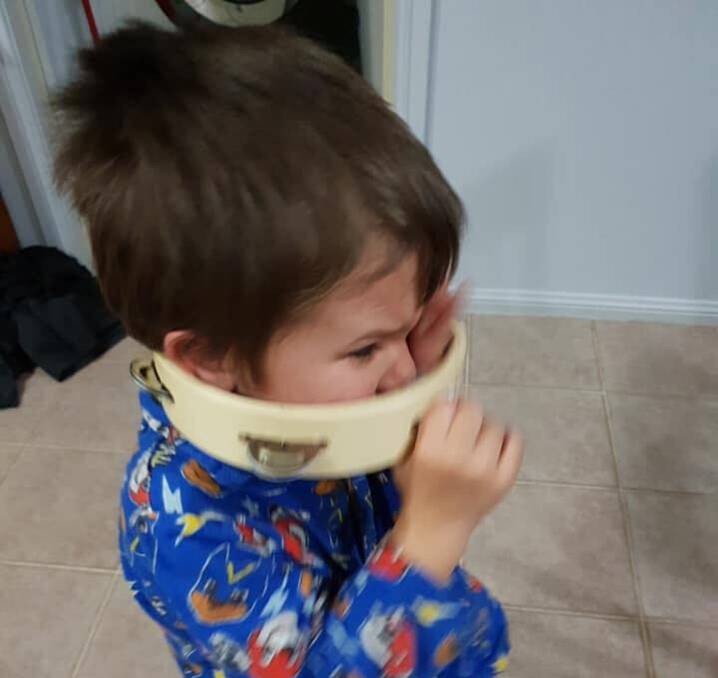 A tambourine stuck on a boy's head. 
