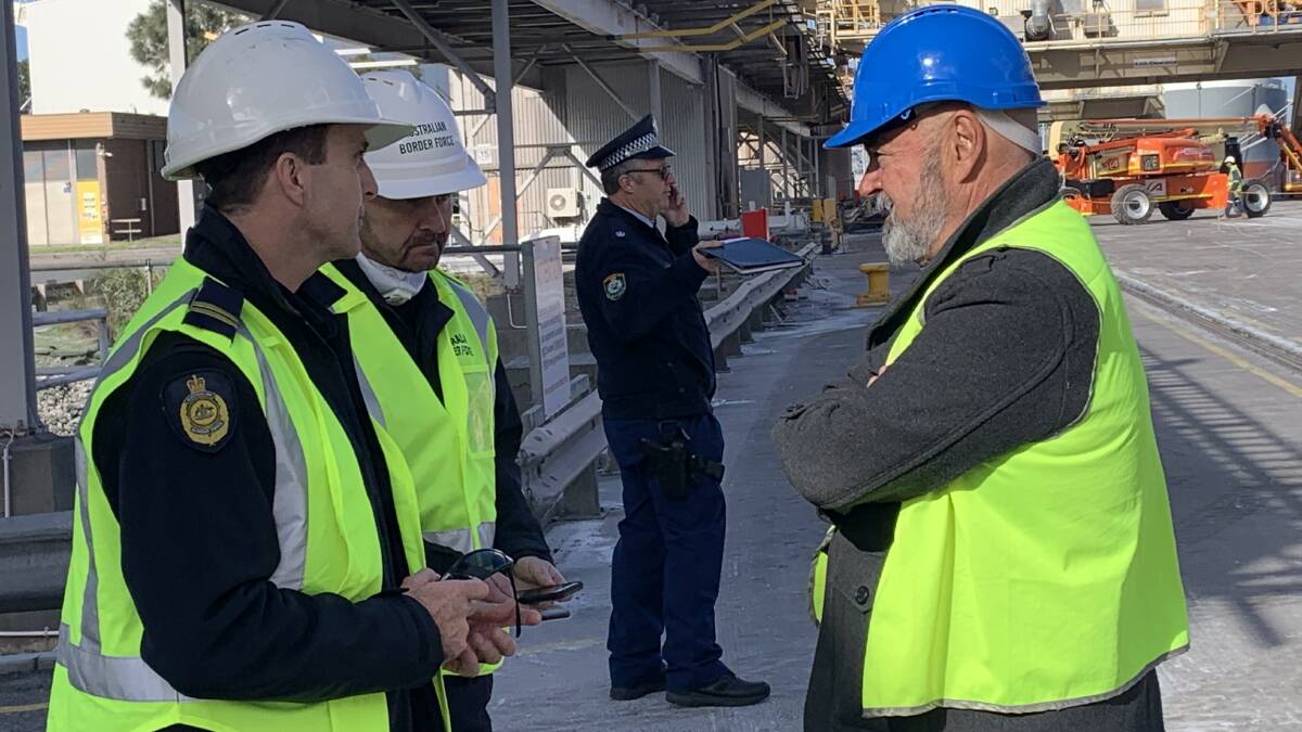 Dean Summers of the ITF, right in blue hat, speaking to Australian Border Force members on the Kooragang 3 wharf today, Friday. 