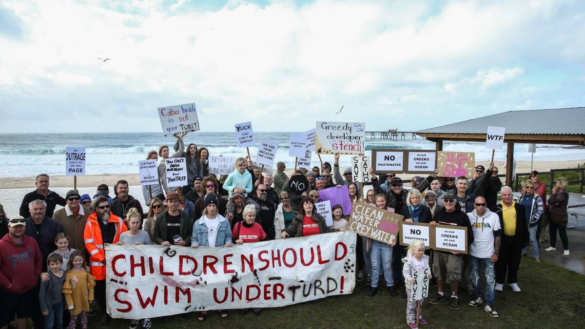NO MESSING ABOUT: Protesters gathered at Catherine Hill Bay on Sunday get their message clearly across. The lagoon behind them about to open up to the sea. Picture: Marina Neil