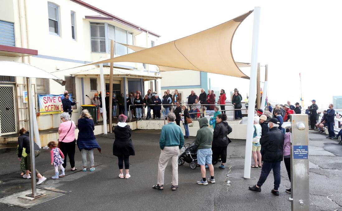 SANDY BOTTOMS: Pool users and Friends of Newcastle Ocean Baths members at the baths yesterday morning, with Tony Brown at the microphone. Picture: Peter Lorimer