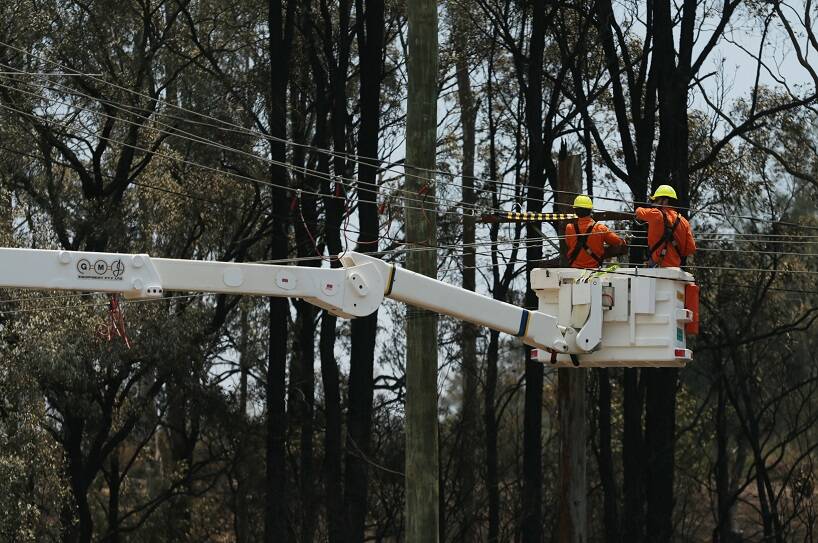 AFTER THE FLAMES: Ausgrid workers repairing bushfire ravaged power lines at North Rothbury in November last year. Picture: Simone De Peak