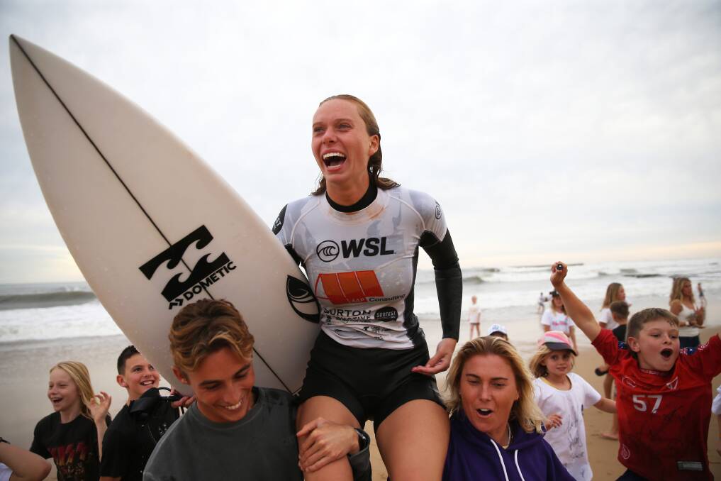 OH YEAH!: Winner Macy Callaghan chaired up by the beach by competitor Dimity Stoyle and friend. Picture: Peter Lorimer/Newcastle Herald