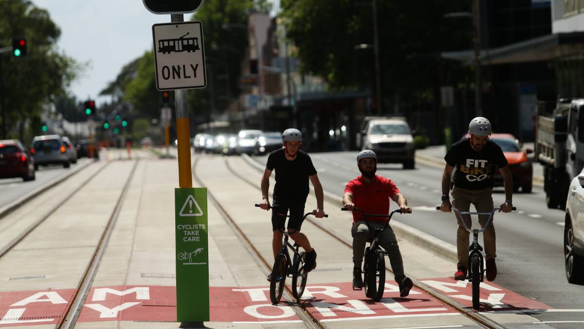Riders on the tracks last weekend despite Revitalising Newcastle's green cycle safety signs and the red "tram only" road markings. Picture: Jonathan Carroll