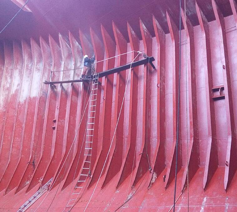 WALKING THE PLANK: Filipino crewman on the Christine B, cleaning the hold of the ship. Picture: ITF