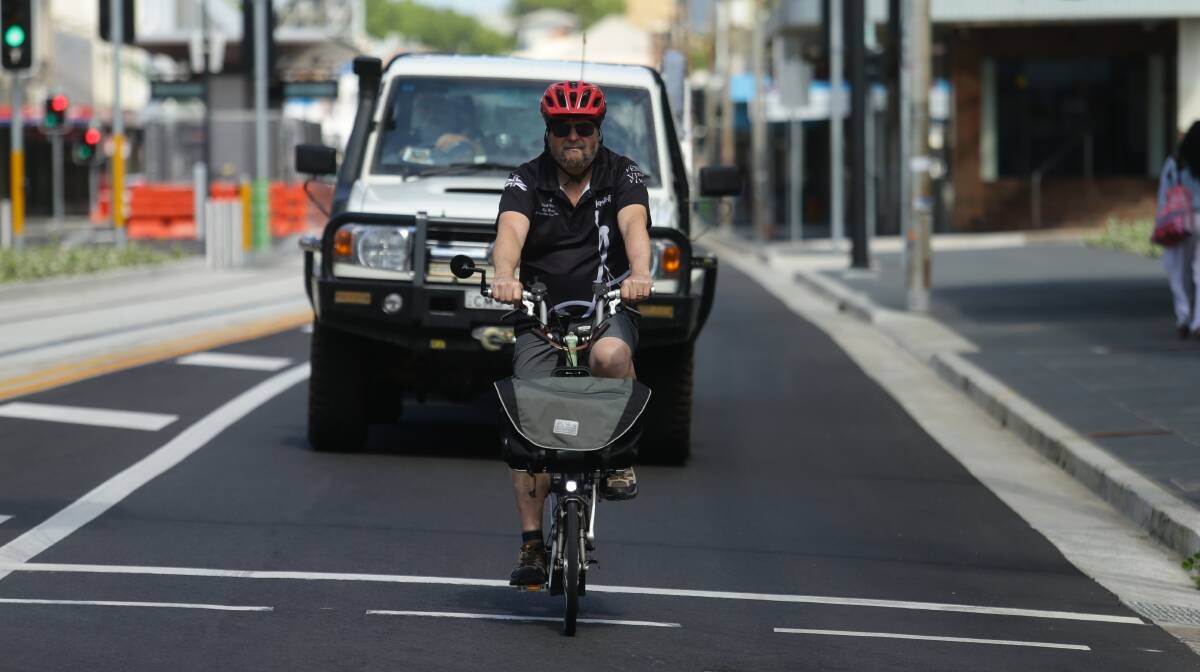 RULES OF THE ROAD: Newcastle Cycleways Movement president Sam Reich, showing how cyclists are being encouraged to "take the lane" as they ride on Hunter Street. Pictures: Jonathan Carroll