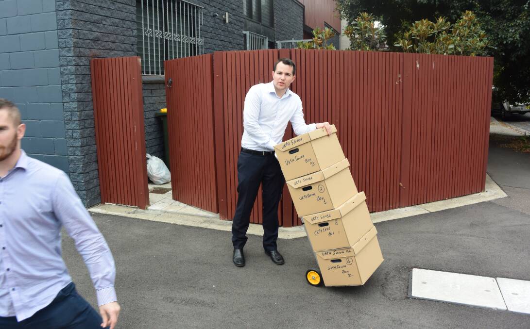 GOING THROUGH THE BOOKS: Jirsch Sutherland supervisor Hayden Asper leaving Urth Energy's Wickham offices yesterday with boxes of documents. The solar-focused power retailer has shut its doors, for the time being at least.