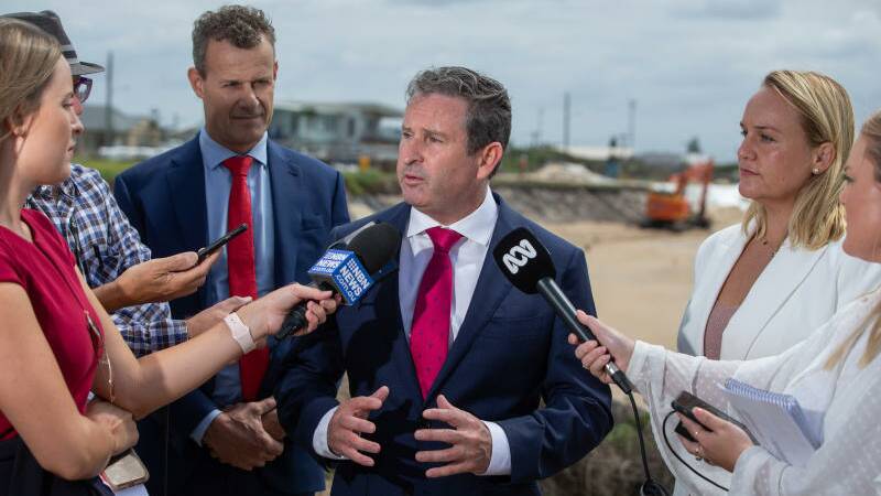 DIGGING IN: Labor state MPs Tim Crakanthorp and Greg Warren with Newcastle Lord Mayor Nuatali Nelmes at Stockton yesterday, while an emergency beach sandbagging operation proceeds behind them. Picture: Marina Neil