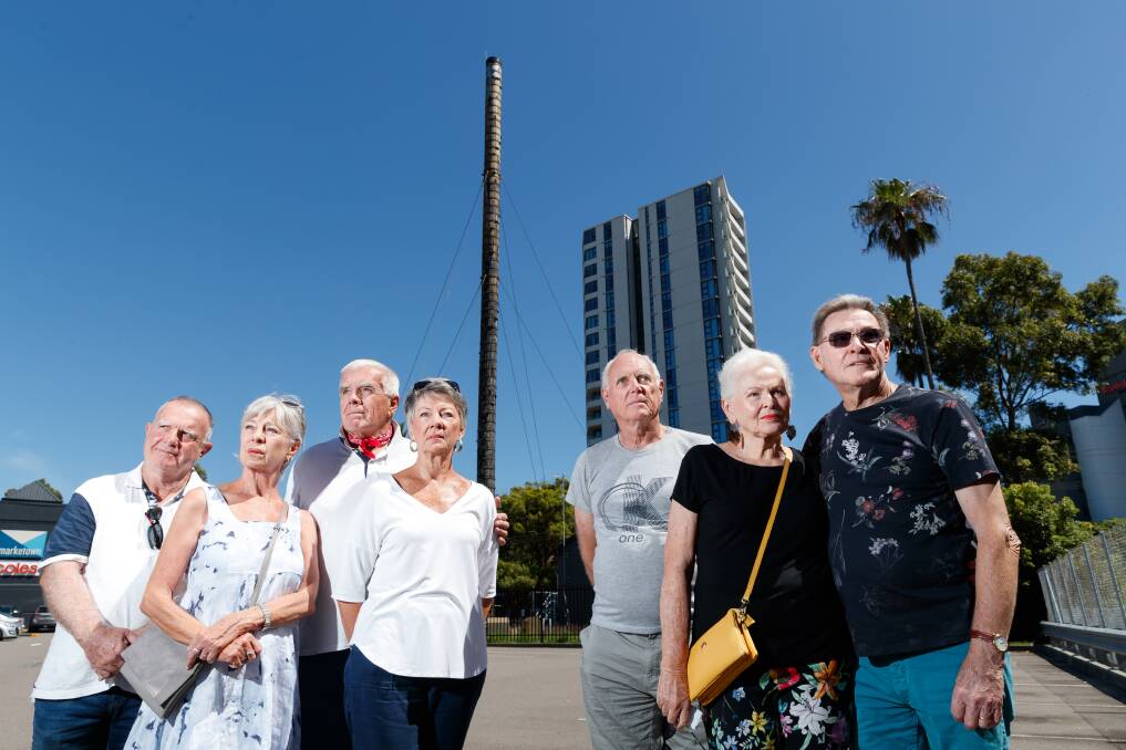 SICK OF THE SMELL: Apartment block residents Stephen Jones, Linda Webster, John Dickenson, Suzanne Kinsman, Peter Rickford, Narelle Heaney and Garry Heaney, with the sewage vent behind them. Picture: Max Mason-Hubers 