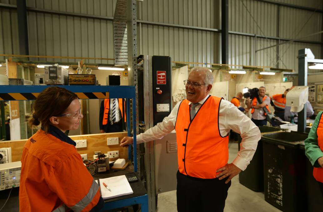 HI-VIZ: Crystal Jolly, a second year electrical apprentice employed by Hunter Valley Training Company and placed with services company EnerMech, with Prime Minister Scott Morrison yesterday. Picture: Jonathan Carroll