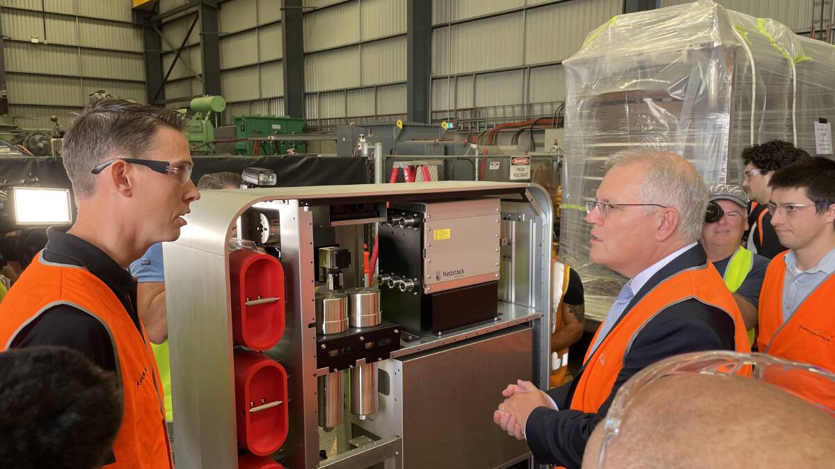 SO THAT'S HOW IT WORKS: Prime Minister Scott Morrison listens as Ampcontrol systems engineer Aaron Breese explains the hydrogen battery yesterday.