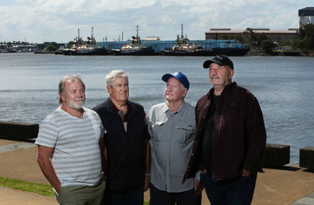 Retired Newcastle tug crew Doug Terry, Chris Visscher, George Sewell and Len Covell at Honeysuckle yesterday, with four of the port's Svitzer's tugs tied up at Carrington in the background. Picture by Simone De Peak