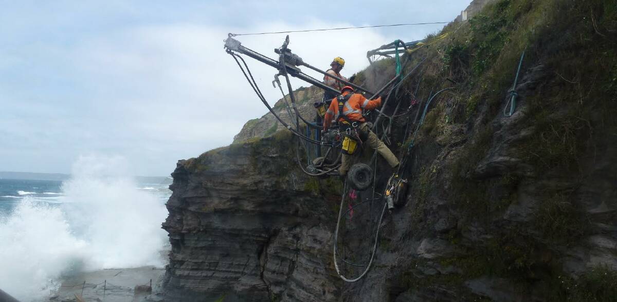 HANGING AROUND: Crew from Newcastle specialists GSS drilling high-tensile steel bolts into the cliff face above the Bogey Hole. Picture: GSS.