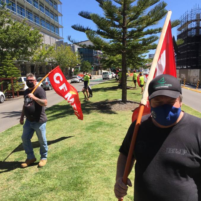 PROTECTED ACTION: Mark Cross of the CFMEU at one of two protests today against a company working on the Huntington apartments (seen here, at the right) at Honeysuckle, and The Foundry apartments at Adamstown. Picture: Ian Kirkwood