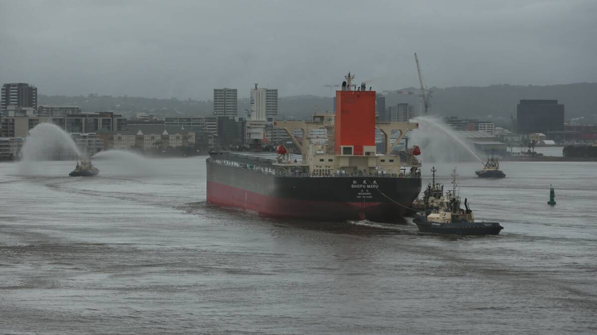 The Shofu Maru heads past the foreshore with the tug water canons putting on a show. Picture by Simone De Peak