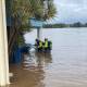 DANGER: Fire and Rescue personnel donned safety equipment to secure gas tanks which had come adrift in floodwaters at Taree Aquatic Club this morning. Picture: FRNSW