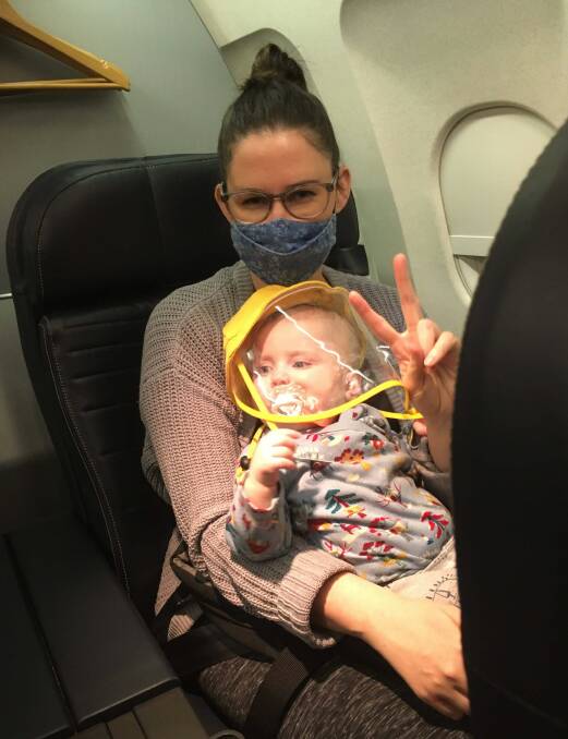 COVID-19: Sally Booth and her daughter Maggie onboard a plane on their long trip home to Australia. Everyone on the flight wore masks to reduce contamination risks.