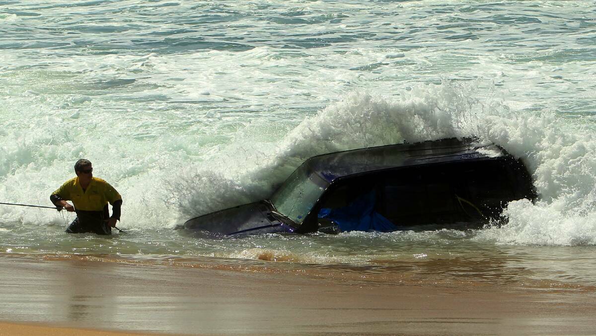 A picture from the 2014 Herald archives when a vehicle was found in the surf at Stockton Beach. Picture by Jonathan Carroll
