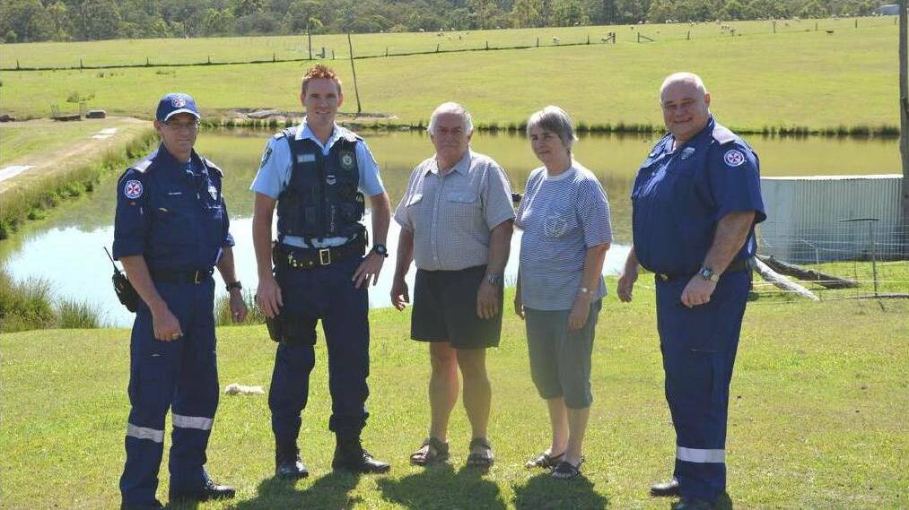  OCTOBER 2015: Dungog paramedics Graeme Scriven and Paul Alexander (on right), Senior Constable Mitch Parker with Bob and Ann Watkins. The dam where the incident occurred is in the background.
