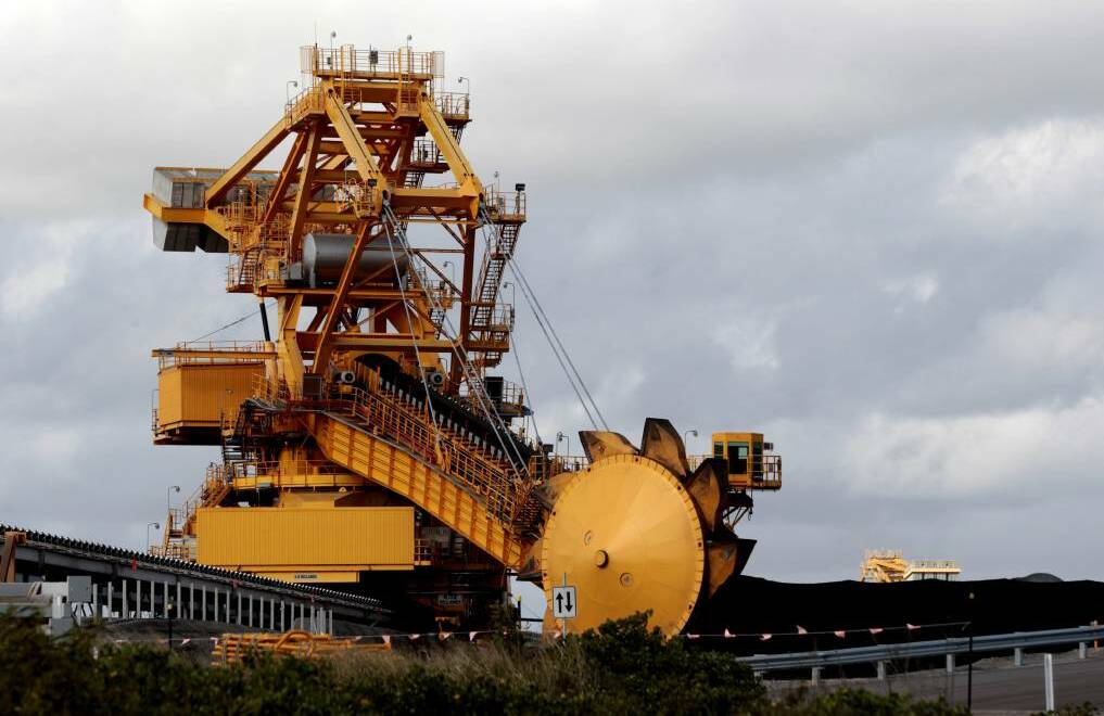 GIANTS: A stacker-reclaimer operating between coal stockpiles at Port Waratah Coal Service's Kooragang Coal Terminal. Picture: Darren Pateman