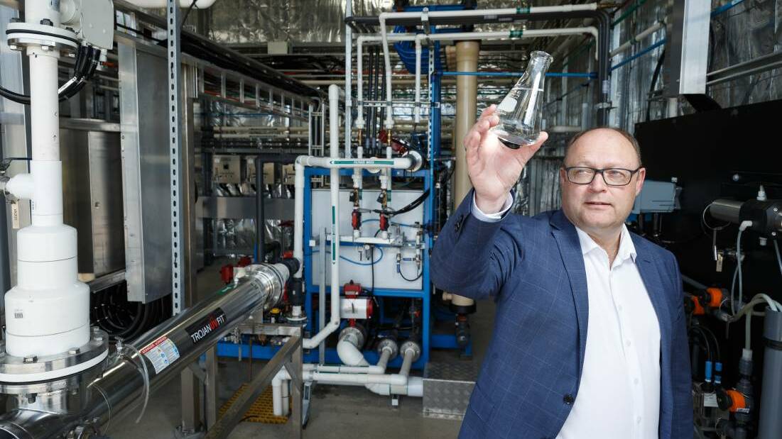CLEAR: Managing director of Hunter Water Jim Bentley with a beaker of recycled water at the Morpeth treatment plant. Picture: Max Mason-Hubers