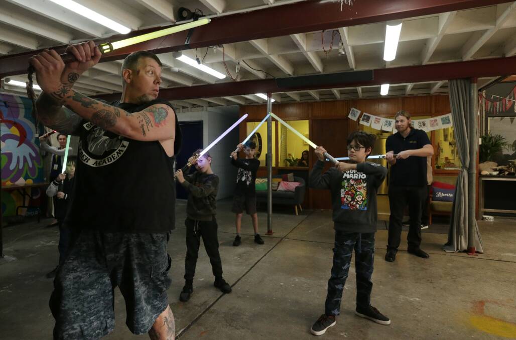 THE FORCE: Luke Boynton of Sons of Obiwan Lightsaber Academy teaching children with vision impairments how to battle. Picture: Simone De Peak 