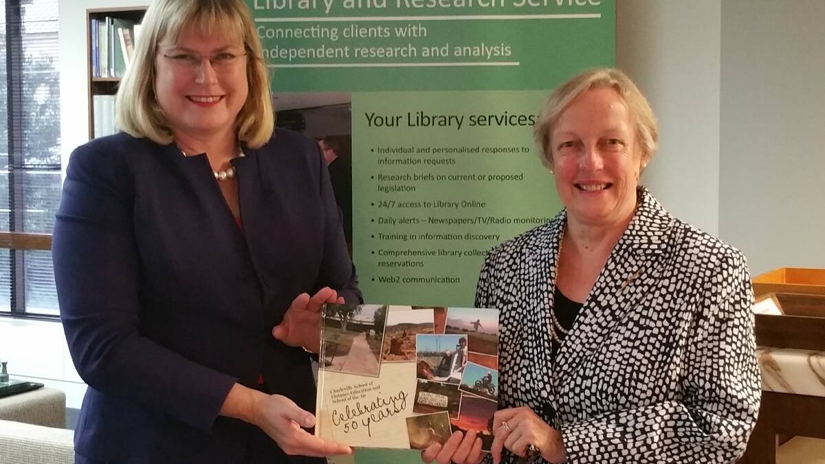 Warrego MP Ann Leahy making a presentation of the history to Katherine Brennan, Parliamentary librarian at the Parliamentary Library.