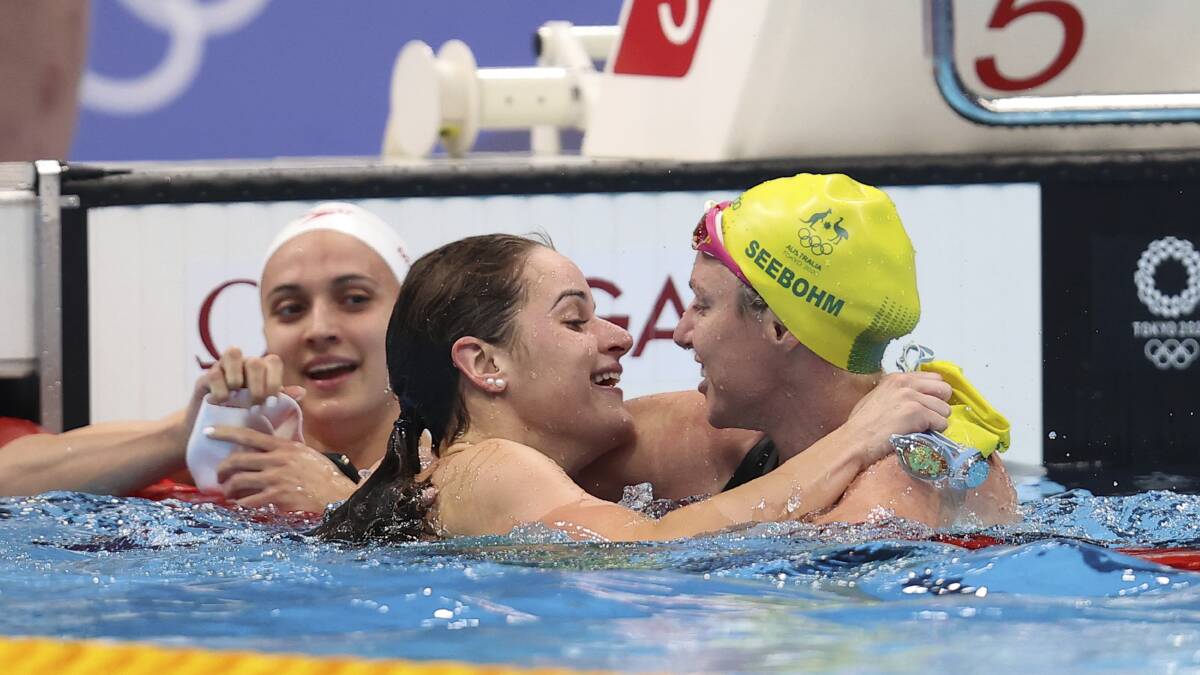 Kaylee McKeown, centre, is congratulated by Australian teammate Emily Seebohm after winning gold in the 100m backstroke final. Picture: AP