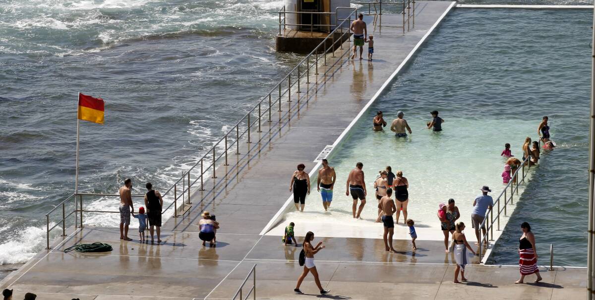 Some relief: Swimmers taking a dip at Merewether Baths an hour before it was scheduled for cleaning by Newcastle council staff on Thursday. Picture: Darren Pateman
