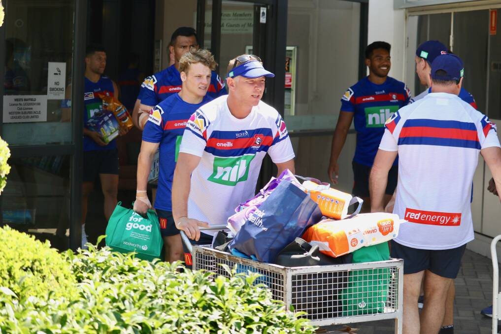 LEADING BY EXAMPLE: Newcastle coach Adam O'Brien pushes a trolley load of groceries bound for victims of the northern NSW bushfires. Pictures: Knights Media