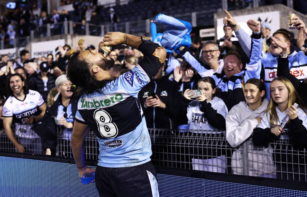 MAN OF THE PEOPLE: Toby Rudolf celebrates the Sharks' win against the Bunnies by sharing a beer with a punter. Who cares about COVID? Picture: Getty Images