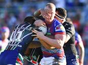 WRAPPED UP: Newcastle's Mitch Barnett is tackled by the Warriors on Saturday. Picture: Getty Images