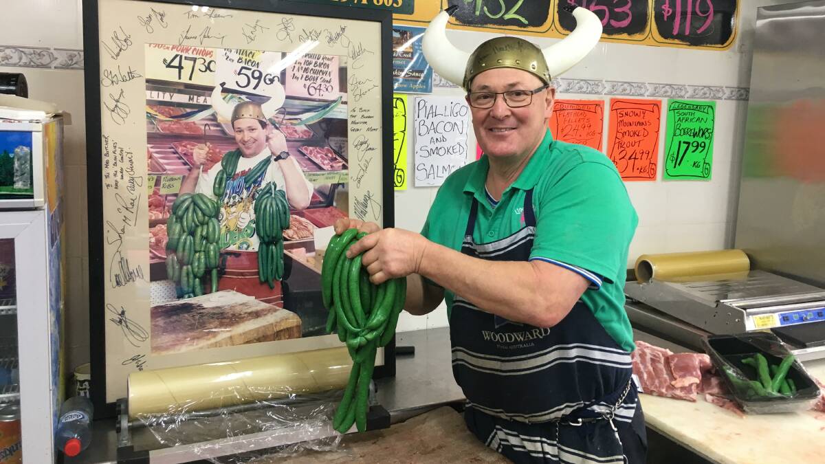 BON APPETIT: Canberra butcher Peter Lindbeck displays his famous green sausages before last season's grand final. Apparently they are best served within a week of being cooked.