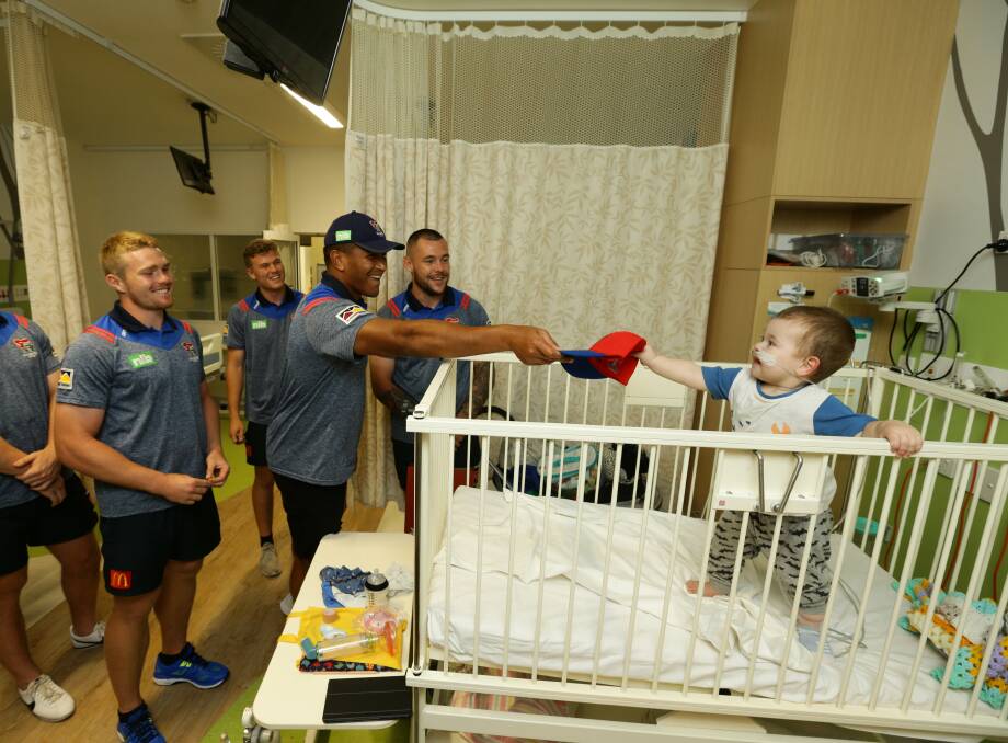LENDING A HAND: Newcastle Knights forward Daniel Saifiti hands a cap to Tyson Porter at John Hunter Children's Hospital on Friday. Pictures: Jonathan Carroll
