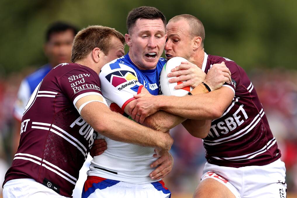 Newcastle's Tyson Gamble runs into a crunching Manly tackle on Saturday. Picture by Getty Images