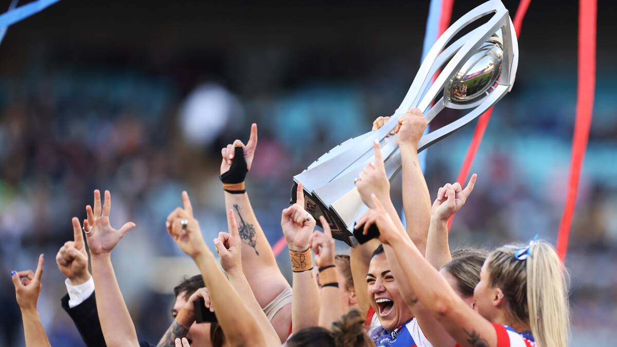 Newcastle Knights skipper Millie Boyle and her teammates with the spoils of victory after their grand final victory against Parramatta on Sunday. Picture Getty Images