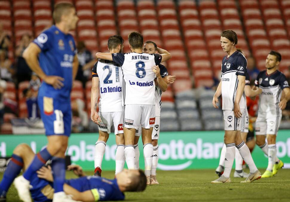 BODY BLOW: Newcastle players look dejected as Melbourne Victory celebrate taking a 1-0 lead after a Terry Antonis goal at McDonald Jones Stadium. Pictures: Darren Pateman, AAP