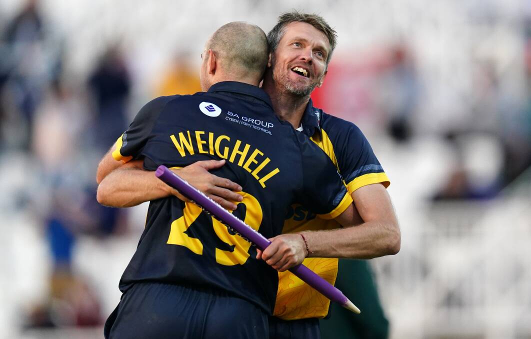 WORTH THE WAIT: Michael Hogan grabs a souvenir stump and shares a celebratory hug with teammate James Weighell. Picture: Getty Images