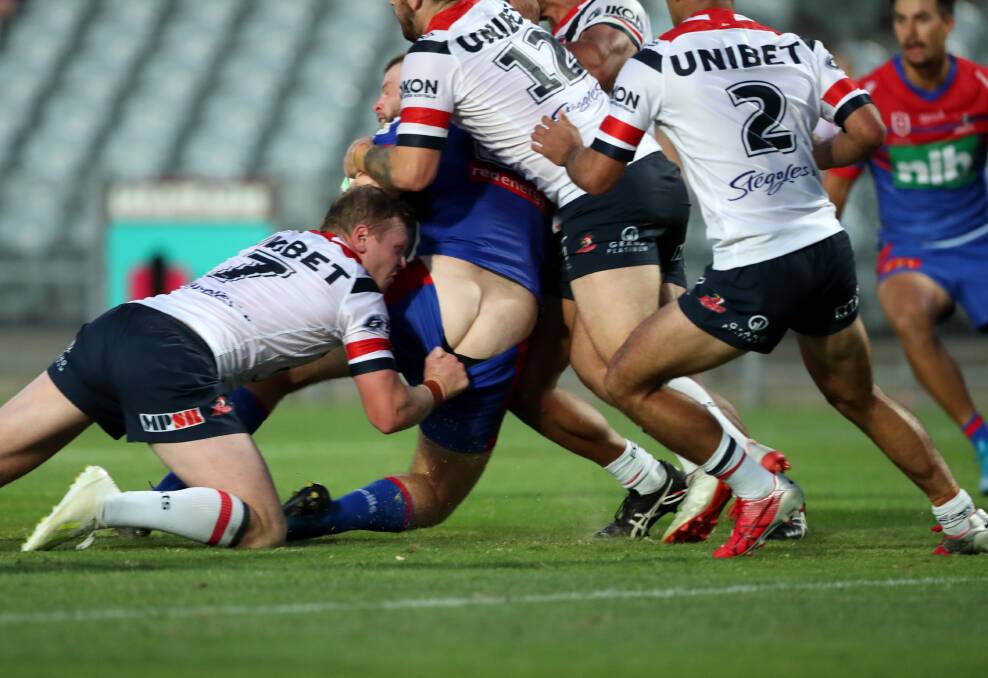 SHORT SHRIFT: The Roosters get up close and personal with Newcastle forward Lachlan Fitzgibbon during the recent trial match in Gosford. Picture: Getty Images