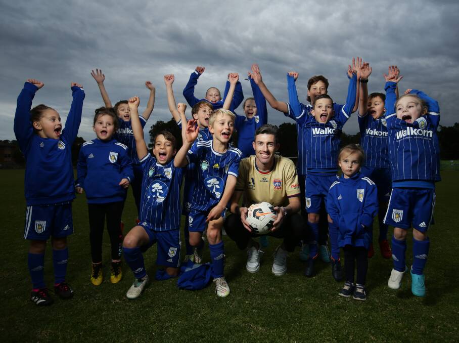 Jets veteran Jason Hoffman with young fans at his former club, Newcastle Olympic. Picture by Simone De Peak