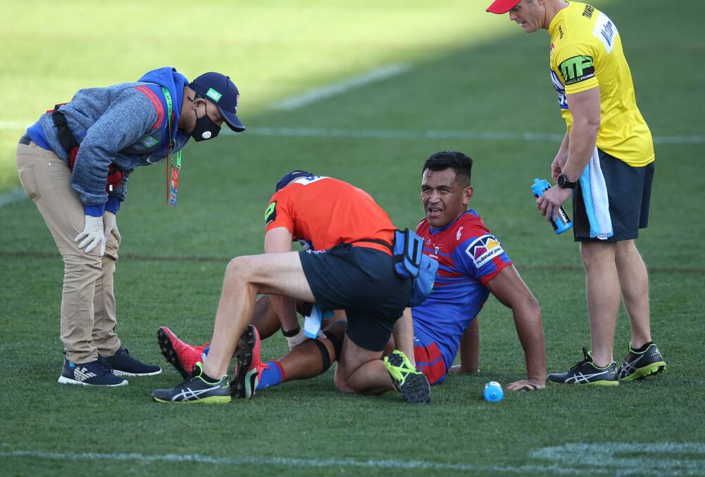 RUNNING REPAIRS: Newcastle's medical staff examine Daniel Saifiti after he re-injured his left knee in Sunday's win against Manly. Pictures: Simone De Peak