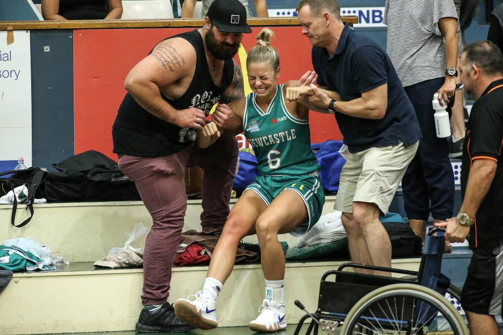 OUCH: Cassidy McLean is helped off the court after suffering a knee injury on Saturday. Picture: Marina Neil