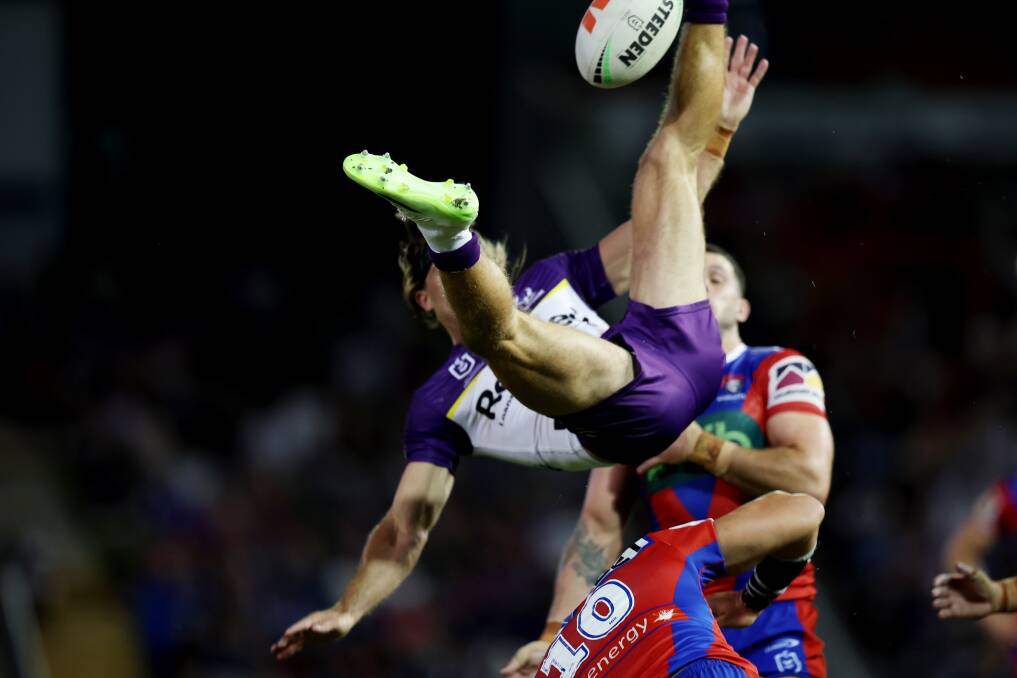 Knights prop Leo Thompson upends Storm fullback Ryan Papenhuyzen. Pictures by Peter Lorimer