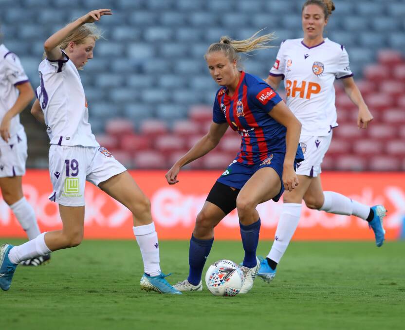 POSSESSIVE: Newcastle's Tara Andrews controls the ball despite the challenge of Perth's Hana Lowry at McDonald Jones Stadium on Thursday night. Picture: Getty Images