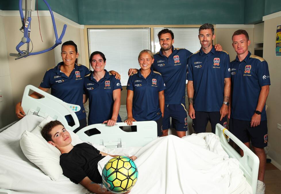 Newcastle Jets players pay 16-year-old Blake a visit at John Hunter Hospital children's ward on Thursday. Picture by Peter Lorimer